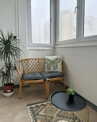 a bench with a butterfly pillow and a table at Apartman Lagom in Banja Luka
