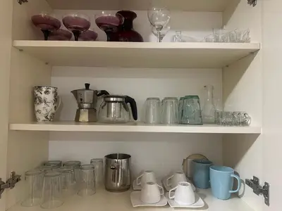 a shelf with various glass items on it at Apartman Lagom in Banja Luka