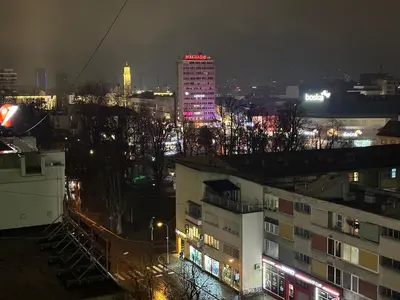 a city at night with lights on a tall building at Apartman Lagom in Banja Luka
