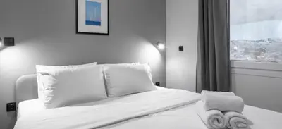 a bedroom with a bed with white sheets and pillows at Nikstudio in Banja Luka