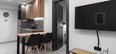 a kitchen with a table and a television on a wall at Nikstudio in Banja Luka
