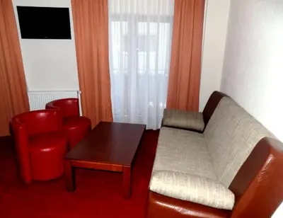 a living room with a couch and a table and chairs at Hotel Knez in Kupres