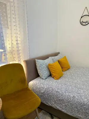 a couch with two pillows and a chair in a room at Sanak in Ivišovo Greblje