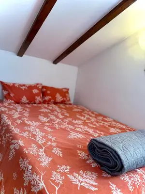 a bedroom with a bed with a red comforter at Sanak in Ivišovo Greblje