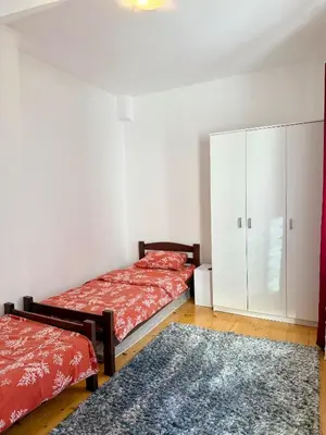 a bedroom with two beds and a white cabinet at Sanak in Ivišovo Greblje