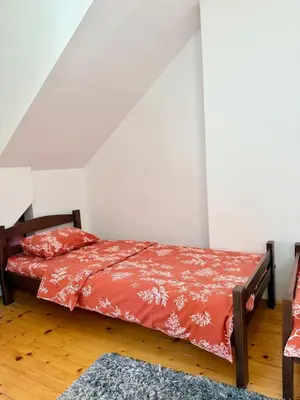 a bedroom with a bed with a red comforter at Sanak in Ivišovo Greblje