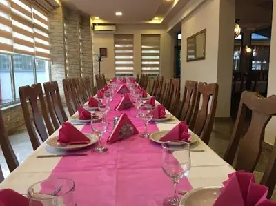 a long table with pink napkins and wine glasses at Hotel Split in Usora