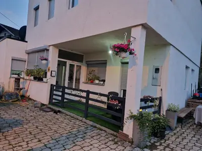 a house with a porch and a fence and flowers at RIVERSUN Home in Bihać