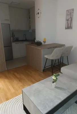 a living room with a table and a kitchen at Apartman Andrija in Banja Luka