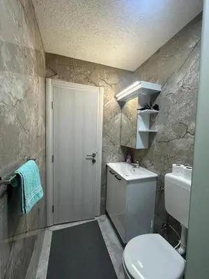 a bathroom with a white toilet and a sink at Apartments Aventra in Visoko