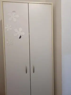 a white cabinet with flowers painted on it at Apartman Magelan in Bosanska Gradiška