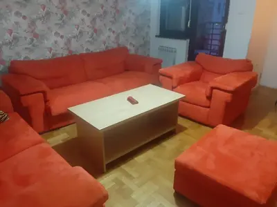 a living room with orange couches and a coffee table at Apartment No1 in Banja Luka