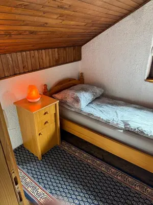 a small room with two beds and a night stand at Wooden house Tešanj in Tešanj