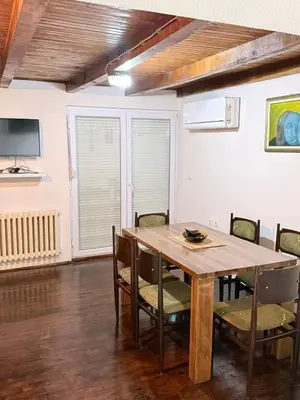 a dining room with a wooden table and chairs at Wooden house Tešanj in Tešanj