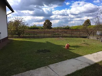 a red fire hydrant in a yard next to a fence at Vikendica Brvnička Oaza mir i priroda kraj Šamca
