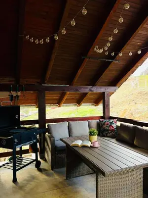 a porch with a couch and a table and a piano at Apartman Slapovi in Banja Luka