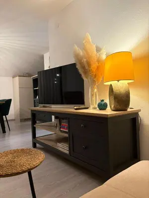 a living room with a table with a lamp and a tv at Apartman Slapovi in Banja Luka