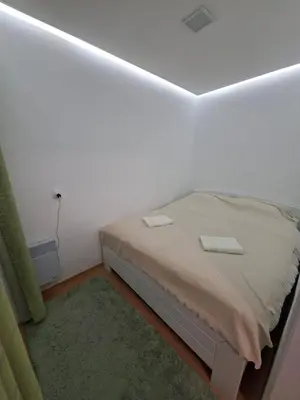 a bedroom with a bed in a white room at Stan na dan Čaršija in Gračanica