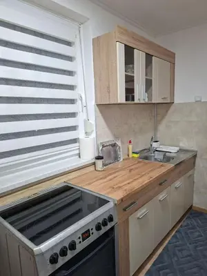 a kitchen with a stove and a sink and a window at Stan na dan Čaršija in Gračanica