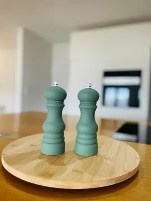 two green chess pieces sitting on a wooden board at Amely in Bihać