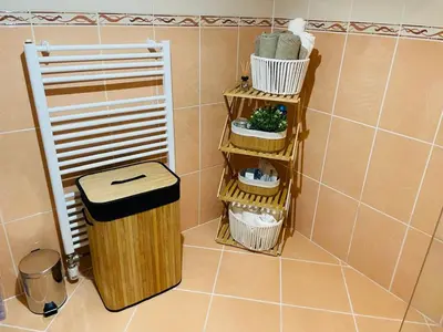 a bathroom with three baskets and a trash can at Amely in Bihać