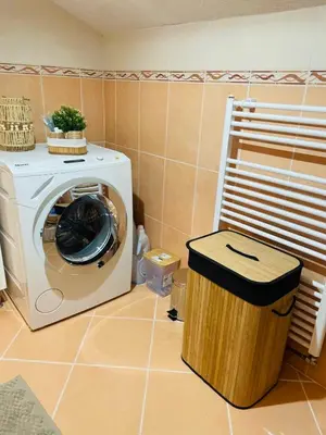 a washing machine in a room with a trash can at Amely in Bihać