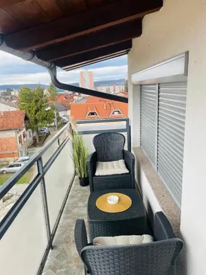 a balcony with chairs and a table on a balcony at Amely in Bihać