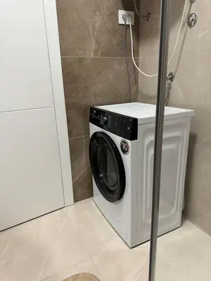 a washing machine in a bathroom next to a cabinet at D&Ana in Banja Luka