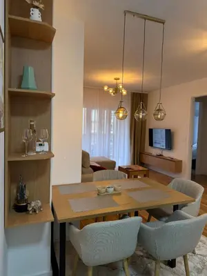 a dining room and living room with a table and chairs at D&Ana in Banja Luka