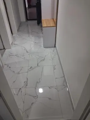 a hallway with a white marble floor with a refrigerator at Jagoda stan na dan in Prijedor