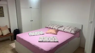 a bedroom with a bed with pink sheets and pillows at Arden House - Mountain Escape with Pool in Mali Radić