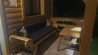 a porch with a blue couch and a table at Arden House - Mountain Escape with Pool in Mali Radić