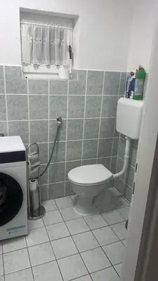 a bathroom with a toilet in a tiled floor at Arden House - Mountain Escape with Pool in Mali Radić