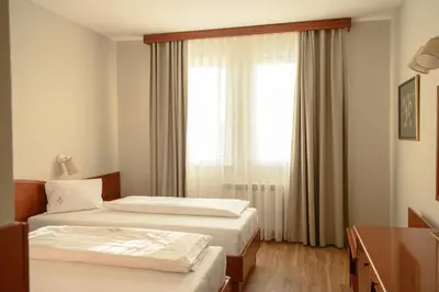 two beds in a hotel room with a window at New Lake in Laktaši