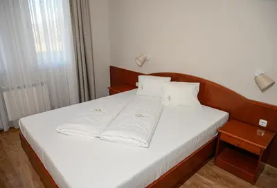 a bed with white sheets and pillows in a room at New Lake in Laktaši