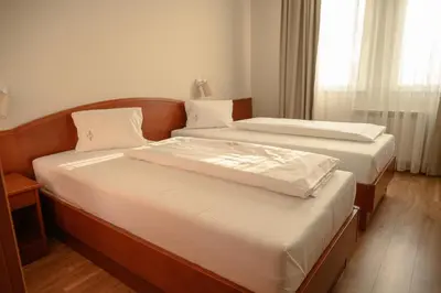 two twin beds in a room with a window at New Lake in Laktaši