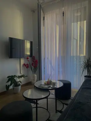 a living room with two tables and a tv at Apartman Blagojević in Banja Luka
