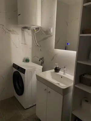 a bathroom with a washing machine and a sink at Apartman Blagojević in Banja Luka