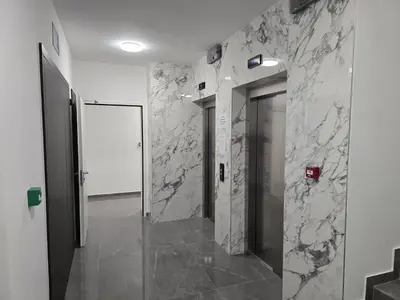 a bathroom with marble walls and a hallway with a door at Lux Apartments Maya 2 in Banja Luka