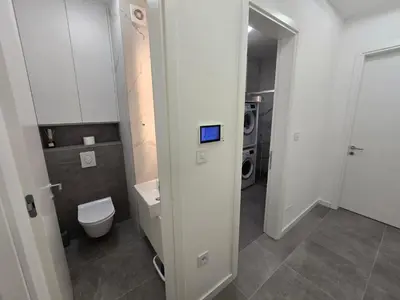 a bathroom with a toilet and a washing machine at Lux Apartments Maya 2 in Banja Luka