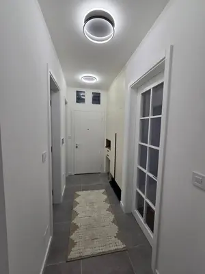 a hallway with a white door and a rug at Lux Apartments Maya 2 in Banja Luka