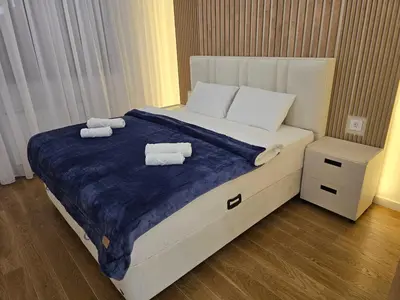 a bedroom with a large bed with two towels on it at Lux Apartments Maya 2 in Banja Luka