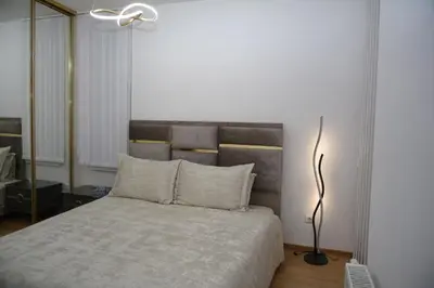 a bedroom with a large bed with a lamp at Elite Centar Lux in Banja Luka