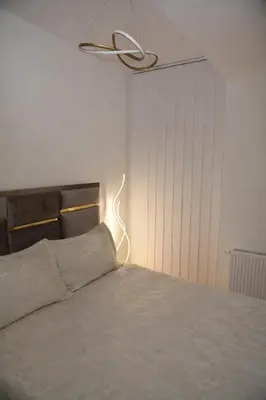 a bedroom with a bed with a light above it at Elite Centar Lux in Banja Luka