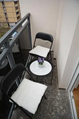 a balcony with two chairs and a table with flowers on it at Elite Centar Lux in Banja Luka