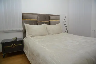 a bedroom with a large bed and a night stand at Elite Centar Lux in Banja Luka