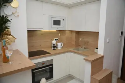 a small kitchen with white cabinets and a sink at Elite Centar Lux in Banja Luka