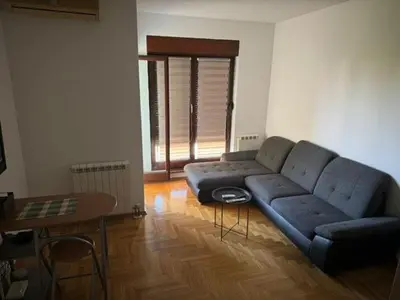 a living room with a blue couch and a table at Trojka in Banja Luka