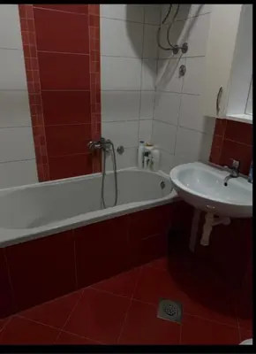 a bathroom with a bath tub and a sink at Trojka in Banja Luka