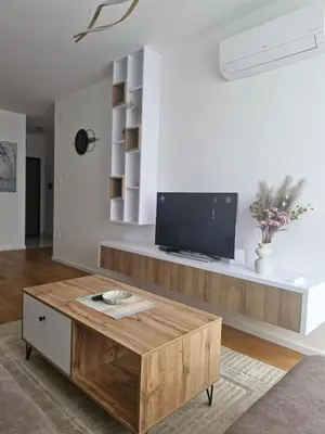 a living room with a tv and a wooden coffee table at Stay & Enjoy Apartment in Banja Luka
